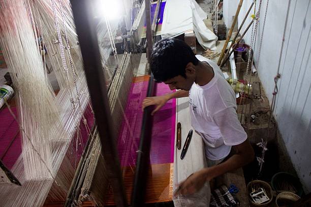 an artisan person weaving a saree