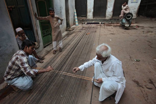 few weaver preparing the warp to wind on a roller